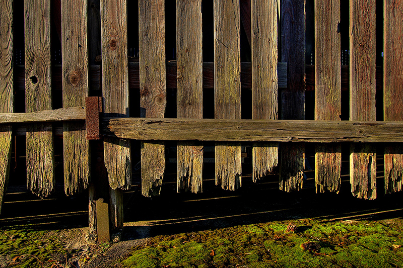 Old weathered wood fence with rotted posts and missing boards